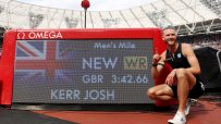 Josh Kerr celebrates new mile record 3:42.66 on Omega scoreboard, Union Jack visible, track stadium background.