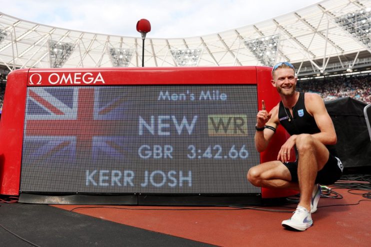 Josh Kerr celebrates new mile record 3:42.66 on Omega scoreboard, Union Jack visible, track stadium background.