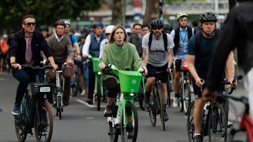London cyclists ride Lime bikes and personal bicycles on a city street, promoting urban mobility and eco-friendly transport.