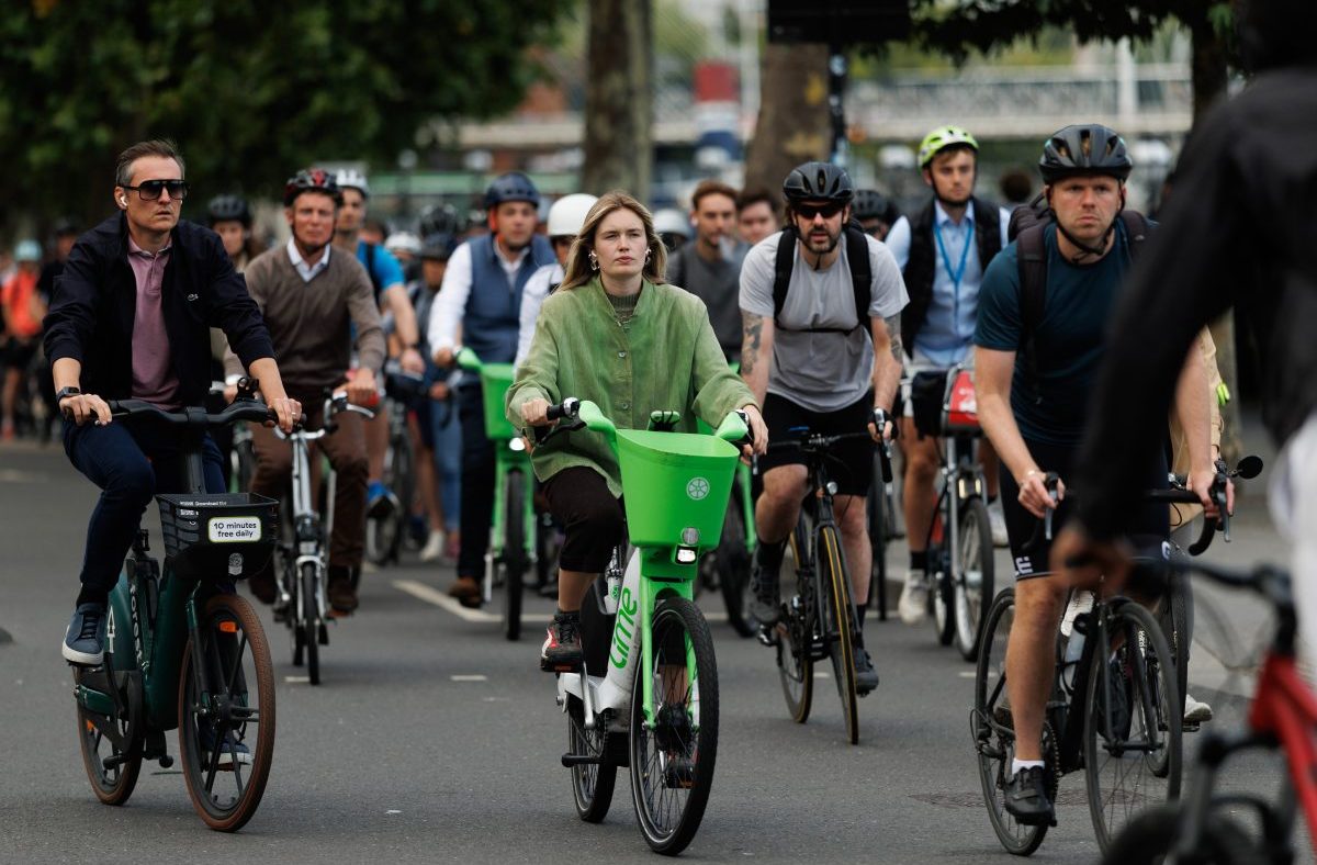 London cyclists ride Lime bikes and personal bicycles on a city street, promoting urban mobility and eco-friendly transport.