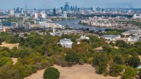 London cityscape from Primrose Hill showing dry, brown grass during drought with River Thames and skyscrapers