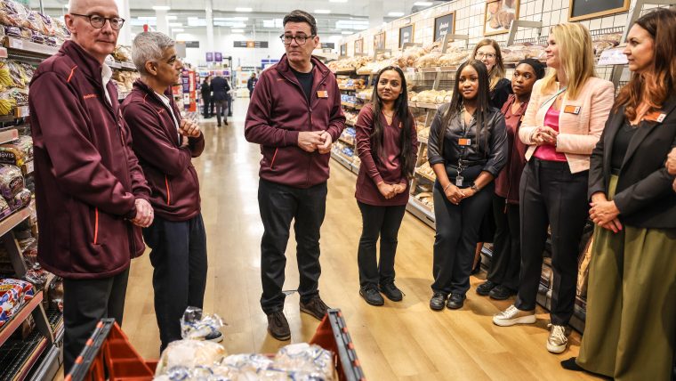 Andy Burnham, Sadiq Khan, and Sainsburys staff discussing Neets numbers in a supermarket bakery aisle.