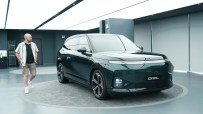 Tim Barnes-Clay observing the new dark green Xpeng G9L electric SUV in a modern showroom in China.