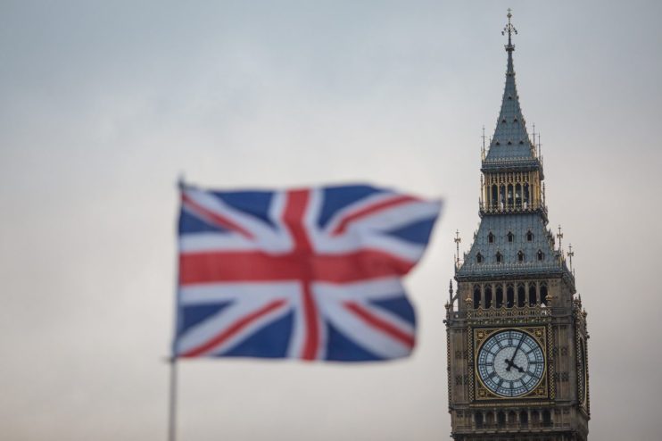 Union Jack flag with Big Ben clock tower and Houses of Parliament in London, UK
