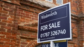 Winkworth estate agent For Sale sign in front of a brick building, indicating property prices and availability.
