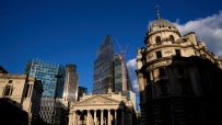 Canada skyline with historic buildings, modern skyscrapers, and construction cranes under blue sky.