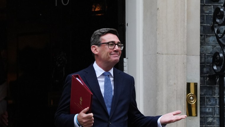 Andy Burnham, Mayor of Greater Manchester, in a dark suit holding a red folder outside 10 Downing Street