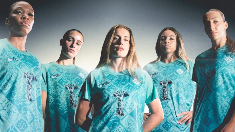 Five female athletes in teal Nike kits with a patterned design and a trophy graphic.
