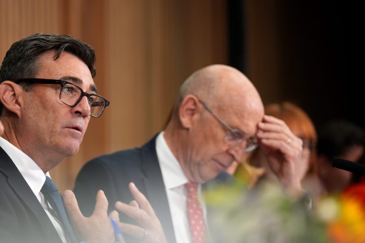 Andy Burnham, Mayor of Greater Manchester, speaking with Chancellor John Healey listening intently in the background.
