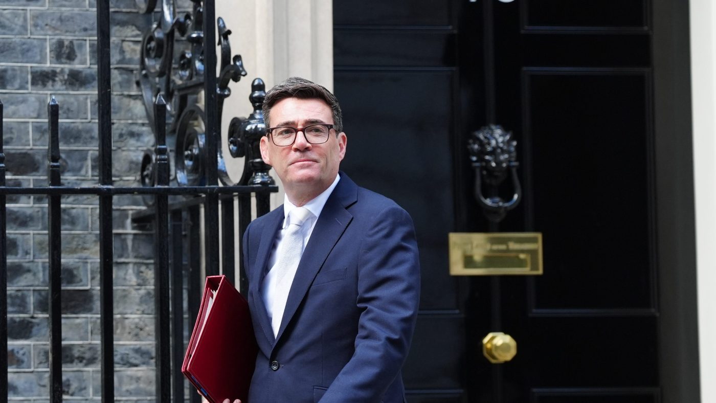 Andy Burnham leaves 10 Downing Street, holding a red folder, in a navy suit and white tie