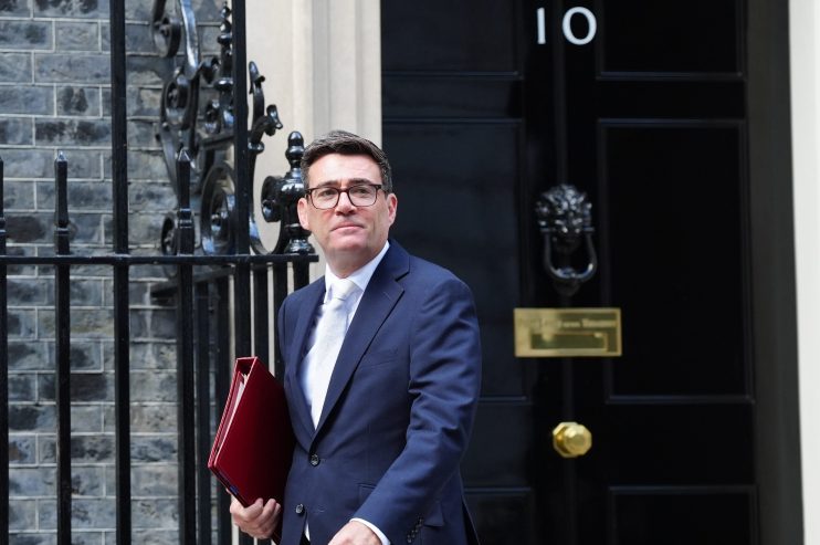 Andy Burnham leaves 10 Downing Street, holding a red folder, in a navy suit and white tie