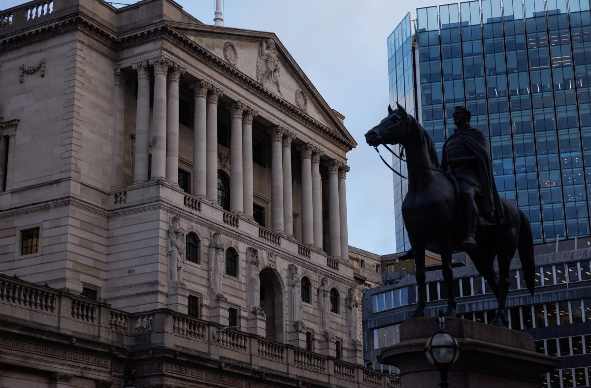 Bank of England facade with classical columns, intricate carvings, and a statue on horseback against a modern glass building.