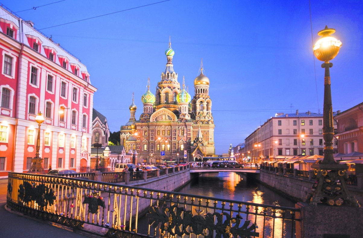 Church of the Savior on Spilled Blood in St. Petersburg at dusk, golden domes and intricate facades illuminated