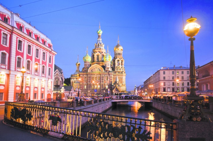 Church of the Savior on Spilled Blood in St. Petersburg at dusk, golden domes and intricate facades illuminated