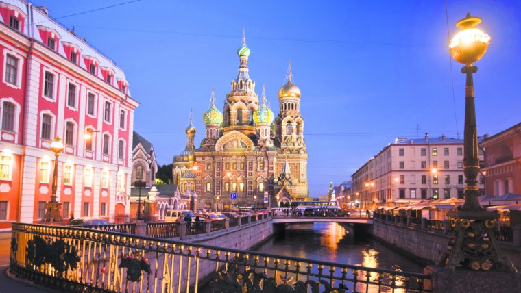 Church of the Savior on Spilled Blood in St. Petersburg at dusk, golden domes and intricate facades illuminated