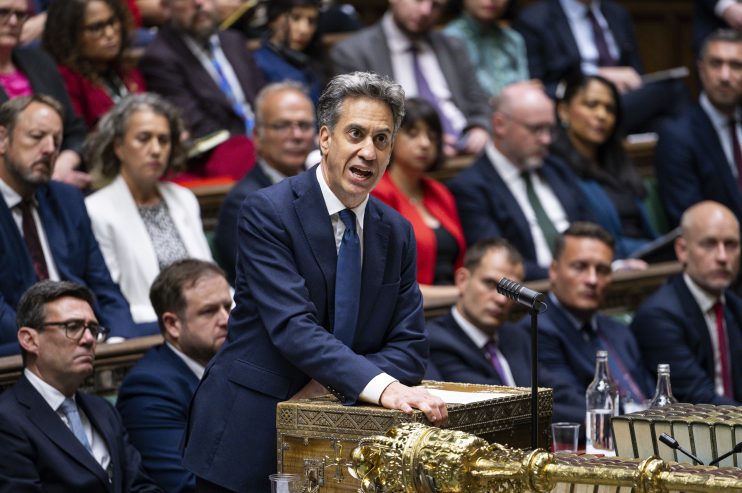 Ed Miliband speaking at dispatch box in the House of Commons, with other Members of Parliament seated behind him.