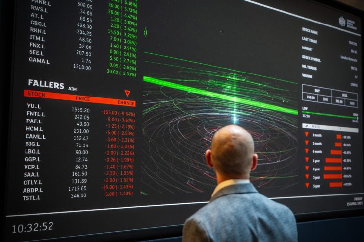 Man views London Stock Exchange screen displaying stock prices, Fallers list, and financial data.