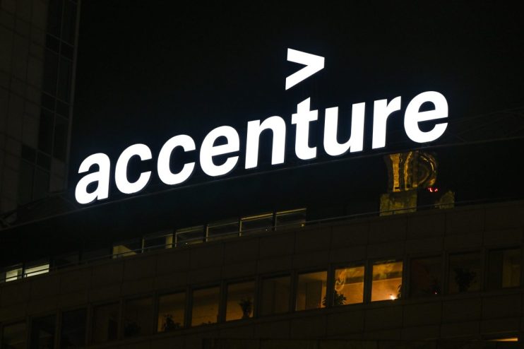Accenture logo illuminated at night on a corporate building, showcasing the companys branding.