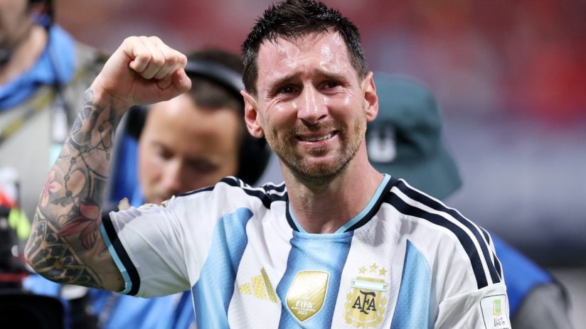 Lionel Messi, sweat-soaked and emotional, clenches his fist in his Argentina jersey after a victory.