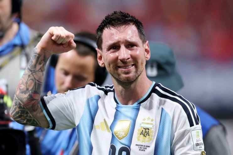 Lionel Messi, sweat-soaked and emotional, clenches his fist in his Argentina jersey after a victory.