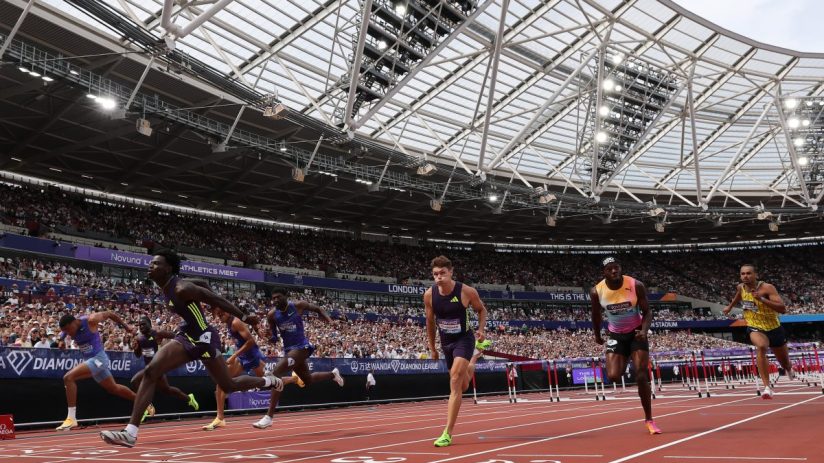 Athletes sprint on a track during a hurdles race at the London Diamond League athletics meet.