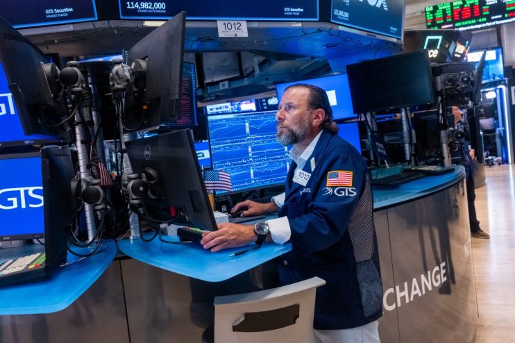 Trader Michael Pistillo at a GTS Securities workstation on the NYSE trading floor, monitors stock data.