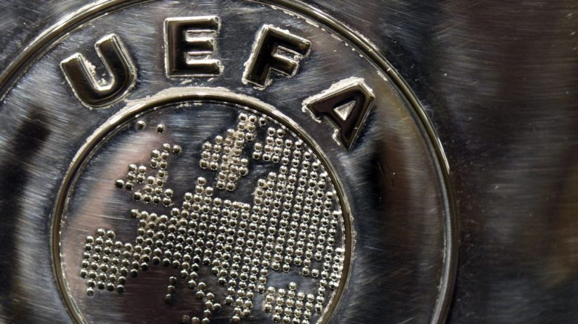 Close-up of a brushed metal UEFA logo with the European continent formed by small spheres.