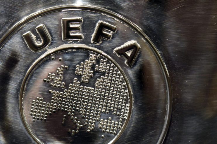 Close-up of a brushed metal UEFA logo with the European continent formed by small spheres.