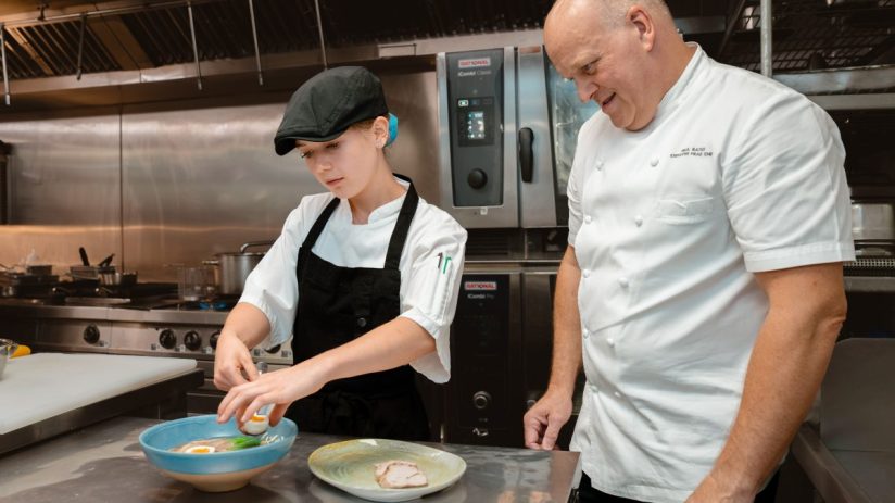 Hilton London Metropole young chef and Head Chef Paul Bates preparing a dish in the kitchen
