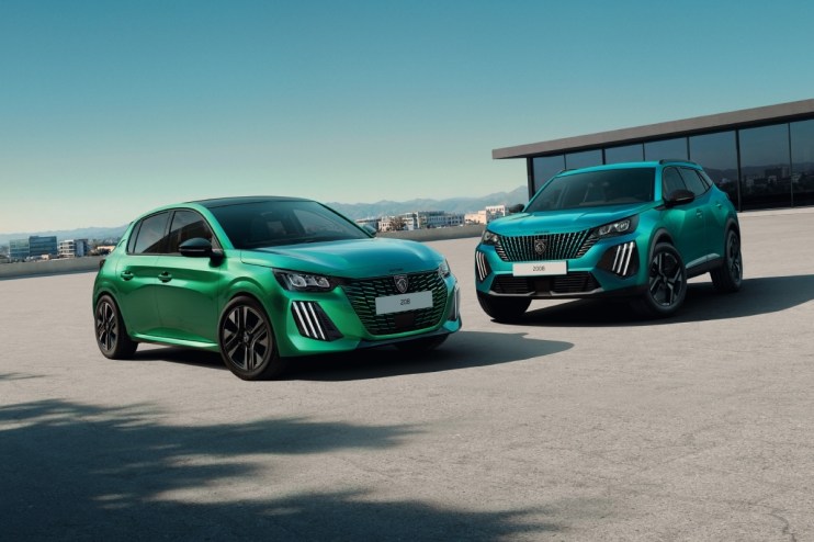 Green Peugeot 208 hatchback and teal Peugeot 2008 SUV parked on a rooftop lot with city views.