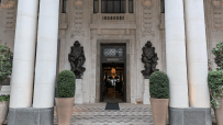 Grand entrance of Six Senses London, featuring large pillars, ornate sculptures, and a WHITELEYS sign above the door.