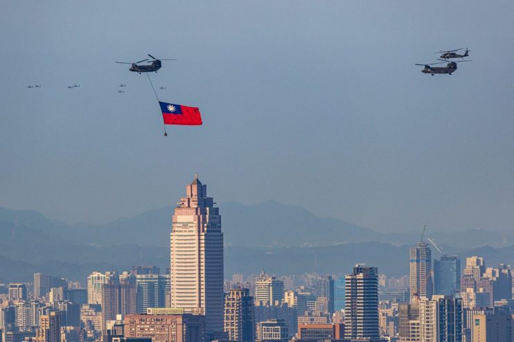 Taiwan flag flyover 2022 with military helicopters above a city skyline and mountains