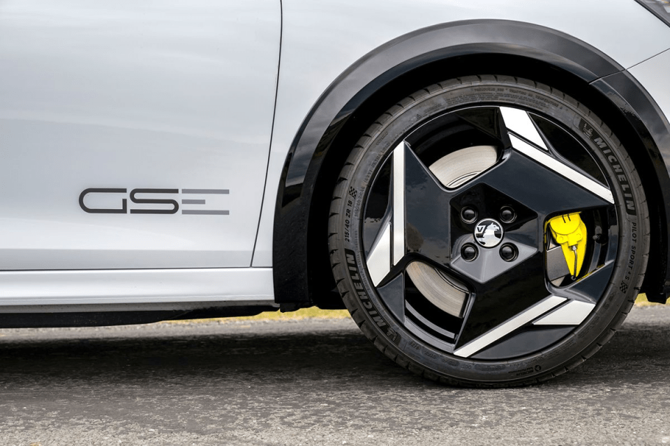 White car side view with black GSE logo, black multi-spoke wheel, Michelin tire, and yellow brake caliper.