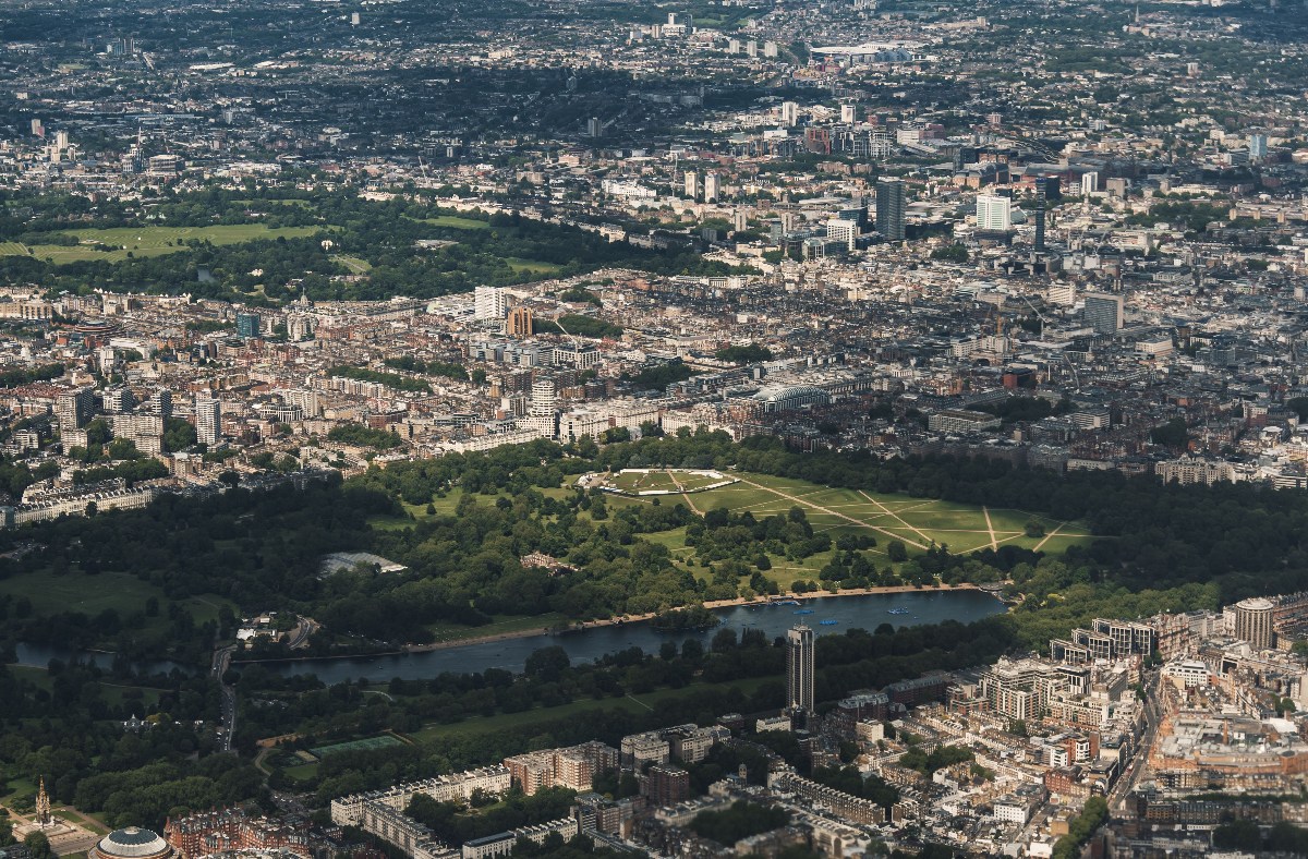 Aerial view of London cityscape with Hyde Park, Serpentine Lake, and surrounding urban buildings